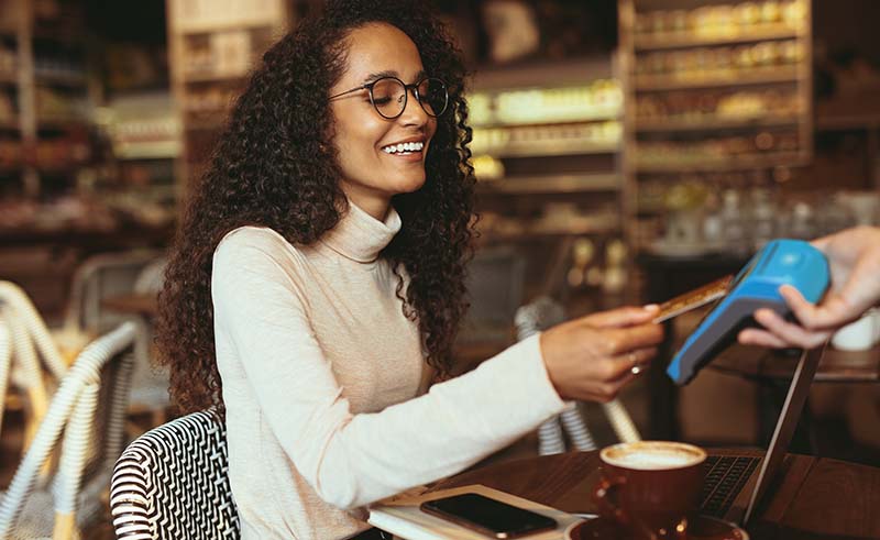 Woman at café paying at the table 
