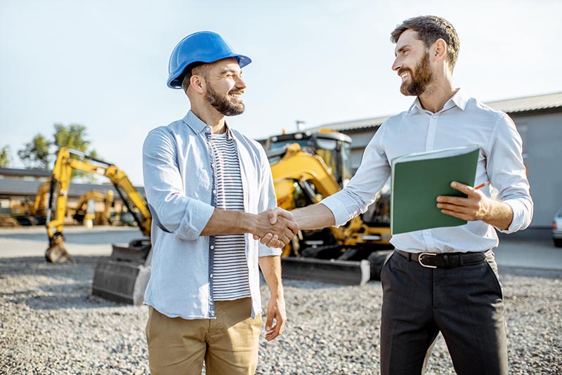 Two construction workers on the job shaking hands. 