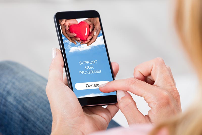 Woman on iPhone donating to her favorite charity. 