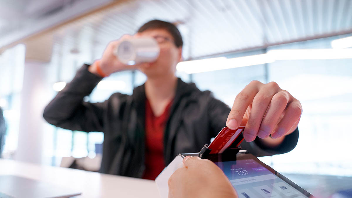 Man orders small coffee while paying with a debit card on a Poynt 5.