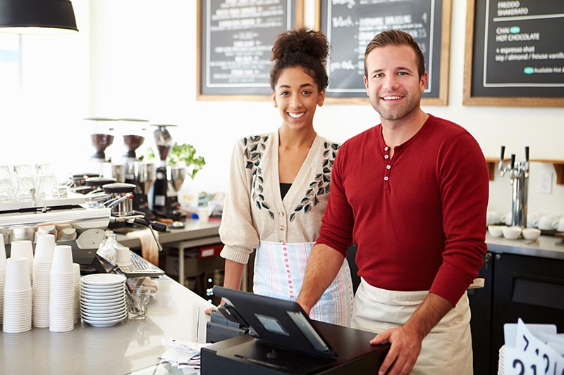Two young coffee shop owners at register. 